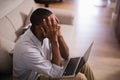 Frustrated man with laptop sitting at home Royalty Free Stock Photo