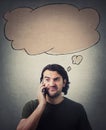 Frustrated man during a phone conversation, makes a dissatisfied expression. Empty thought bubble, thinking cloud, above his head