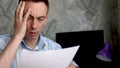 Frustrated man sitting at desk with paper bills. Bankruptcy concept Royalty Free Stock Photo