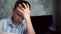 Frustrated man sitting at desk with paper bills. Bankruptcy concept Royalty Free Stock Photo