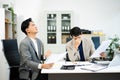 Frustrated manager scolds employee in office over financial error. Concept of workplace stress, reporting issues, conflict Royalty Free Stock Photo
