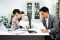 Frustrated manager scolds employee in office over financial error. Concept of workplace stress, reporting issues, conflict Royalty Free Stock Photo