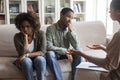 Frustrated married black couple attending family therapist