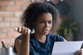 Frustrated millennial young Black woman reading paper letter Royalty Free Stock Photo