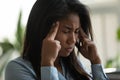 Frustrated mixed race Asian office worker feeling painful migraine