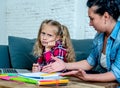 Frustrated mother and bored daughter doing homework together Royalty Free Stock Photo