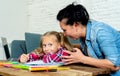 Frustrated mother and bored daughter doing homework together Royalty Free Stock Photo