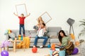 Frustrated mother trying to clean up mess while father playing with children Royalty Free Stock Photo