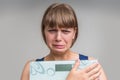 Frustrated overweight woman with scales