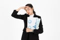 Frustrated overworked and confused young Asian business woman in suit troubled with financial problem over white isolated Royalty Free Stock Photo