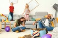 Frustrated parents and their mischievous children in room Royalty Free Stock Photo