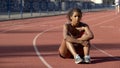 Frustrated with results biracial sportswoman lonely sitting in middle of track
