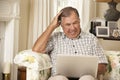 Frustrated Retired Senior Man Sitting On Sofa At Home Using Laptop Royalty Free Stock Photo