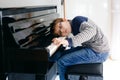 Frustrated sad boy with glasses playing piano in living room. Lonely child learning to play music instrument. Talented Royalty Free Stock Photo