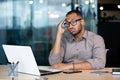 Frustrated and sad man at workplace reading online message from laptop, businessman sitting inside office at workplace Royalty Free Stock Photo