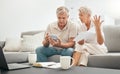 Frustrated senior couple, documents and financial crisis on living room sofa in debt, expenses or bills at home. Mature