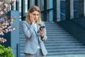 Frustrated and shocked business woman reading bad news online from phone, businesswoman outside office in business suit Royalty Free Stock Photo