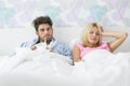 Frustrated sick couple lying in bed at home Royalty Free Stock Photo