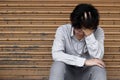 Frustrated stressed young Asian business man covering forehead with hands and feeling disappointed at outside office. Royalty Free Stock Photo