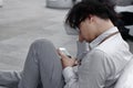 Frustrated stressed young Asian business man using mobile smart phone at outside office Royalty Free Stock Photo