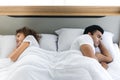 Frustrated stressed young couple in bed lying backs to each other. Relationship and problems couples concept