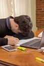 Frustrated student boy, studying in front of a laptop Royalty Free Stock Photo