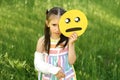 A frustrated sullen sad girl with a broken arm and cast holds a tearful emoji in  hands Royalty Free Stock Photo