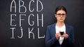 Frustrated teacher showing empty wallet, poor funding, alphabet on blackboard