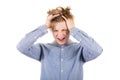 Frustrated teenage boy messing up and pulling his hair, hands to head, looking down shouting and screaming, isolated over white