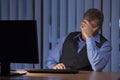 Frustrated tired businessman sitting in a dark blue office