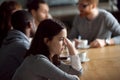 Frustrated upset millennial girl sitting alone at table in cafe