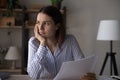 Frustrated upset young woman holding document with bad news