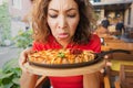 Frustrated woman in a restaurant does not feel the smell and taste of food because of the long covid effect or because of a bad Royalty Free Stock Photo