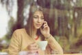 Frustrated woman talking at phone in a coffee shop sitting next to the window Royalty Free Stock Photo
