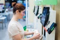 A frustrated woman uses a self-checkout counter. The girl does not understand how to independently buy groceries in the