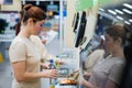 A frustrated woman uses a self-checkout counter. The girl does not understand how to independently buy groceries in the Royalty Free Stock Photo