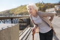 Frustrated woman worrying about her back on the street