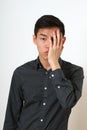 Frustrated young Asian man covering his face with a palm Royalty Free Stock Photo