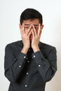 Frustrated young Asian man covering his face with palms Royalty Free Stock Photo