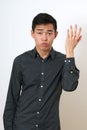 Frustrated young Asian man gesturing with his hand Royalty Free Stock Photo