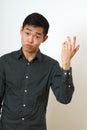 Frustrated young Asian man gesturing with his hand Royalty Free Stock Photo