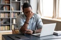 Frustrated young biracial guy taking off eyeglasses, massaging nose bridge. Royalty Free Stock Photo