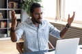 Frustrated young biracial man feeling shocked about online news. Royalty Free Stock Photo