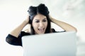 Frustrated young businesswoman holding her head and staring at the laptop Royalty Free Stock Photo