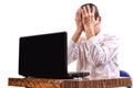 Frustrated young man, holding his head in front of a laptop in t Royalty Free Stock Photo