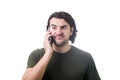 Frustrated young man during a mobile phone conversation, makes a dissatisfied face expression isolated on white background. Royalty Free Stock Photo