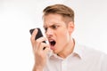 Frustrated young man screaming on his mobile phone Royalty Free Stock Photo