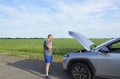 frustrated young man stands on the side of the road near a broken car Royalty Free Stock Photo