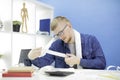 Young man using calculator and shopping receipts managing domestic budget alone Royalty Free Stock Photo