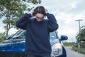 A frustrated young woman in a blue sweater hopelessly breaks down outside when her car fails to start while on a road trip Royalty Free Stock Photo